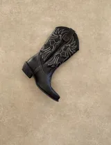 Botas de cuero negro con bordado decorativo en el caño y empeine, taco bajo y punta fina. Diseño de estilo cowboy.