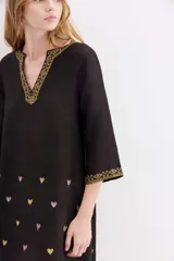 Vestido largo negro de viscosa con bordados de corazones en el cuerpo y ruedo con jacquard de lurex.