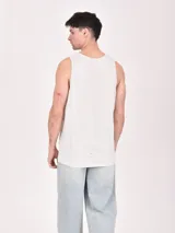 Musculosa blanca de algodón con estampado de un esqueleto surfeando en la playa.