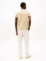 Remera color beige de algodón con cuello redondo y logo bordado de Tommy Hilfiger en el pecho.