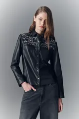 Camisa negra entallada de símil cuero con bordado floral en los hombros, cuello camisero y botones a presión con logo.