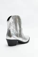 Botas texanas plateadas de caña baja con bordados negros a contratono y taco bajo.