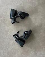 Sandalias negras de plataforma con tiras finas y hebilla al tobillo.