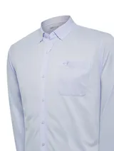 Camisa celeste de manga larga confeccionada en algodón pima y poliéster reciclado. Cuenta con cuello camisero, bolsillo en el pecho y calce regular.