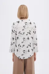 Blusa blanca de manga 3/4 con cuello en V y bolsillo en el pecho.