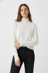 Polera de manga larga color blanco, de tejido de punto fino, con cuello tipo tortuga o cuello alto.