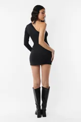 Vestido corto negro de microfibra asimétrico, con una manga larga ajustada al cuerpo. Presenta un nudo en el corpiño, abertura en el abdomen y detalle de frunce en el hombro y la falda delantera.