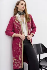 Saco largo de viscosa color fucsia con bordados dorados. Presenta un diseño con guarda bordada en el delantero, escote y puños, cuello redondo y cierre frontal con ganchos invisibles.