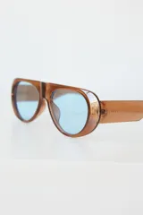 Lentes de sol con montura de acetato color crema y lentes oscuros con protección UV400.