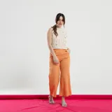 Top sin mangas de color crudo con detalles de bordado floral, tejido en punto.