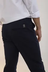 Pantalón de vestir azul marino, de corte slim fit, con bolsillos laterales y traseros.