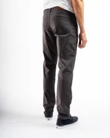 Pantalón de gabardina color beige, de corte recto, con bolsillos laterales y traseros. Se ajusta a la cintura con cinturón de cuero marrón.