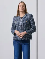Chaqueta tipo blazer en tejido tweed azul con detalles en blanco y lurex. Tiene escote mao, abertura central, bolsillos delanteros y puños con aplique de botones perlados. Terminación desflecada y forro interno.