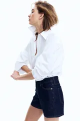 Short de denim azul oscuro, de tiro alto, con cinco bolsillos y cierre con botón.