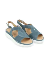 Sandalias de cuero color gris claro con tiras cruzadas y elástico. Suela de plataforma blanca.