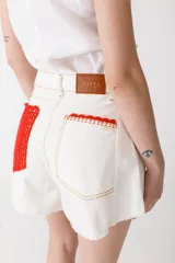 Short de denim de calce amplio y tiro alto, con ruedo desflecado y detalles de crochet en el borde de los bolsillos frontales.