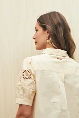 Camisa blanca de mangas cortas abullonadas con calados florales.