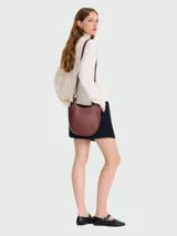 Bolso bandolera pequeño Longchamp modelo Le Foulonné, color marrón oscuro (casi borgoña), con forma curva y correa ajustable delgada.