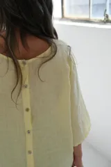 Blusa amarilla de lino con mangas 3/4 y cuello redondo.