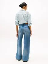 Jean de tiro alto y pierna ancha, confeccionado en denim de lyocell con efecto desteñido integral. Presenta cierre de cremallera oculto con botón y estilo de cinco bolsillos.