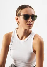 Gafas de sol Eco Shades Fontana con montura redonda gris y lentes verdes. Fabricadas con acetato biodegradable y lentes de PMMA reciclado.