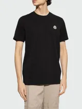 Camiseta negra de algodón con cuello redondo y logo de la marca bordado en el pecho.