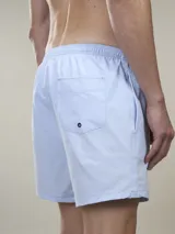 Short de baño verde con estampado de margaritas blancas y cordón ajustable naranja.