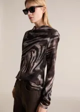 Blusa de manga larga con estampado animal print, cuello alto y cierre de botón en la parte posterior.