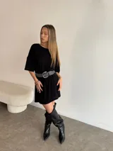 Remerón negro de corte holgado con cinturón con argollas plateadas.