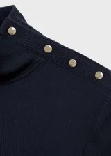 Camiseta blanca de tejido de punto de canalé, corte ajustado, cuello perkins, manga larga y cierre de botones metálicos en el hombro.