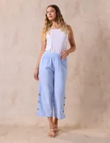 Pantalón crop de algodón celeste con pretina elastizada, bolsillos inclinados y ruedo lateral con tajo y botones.