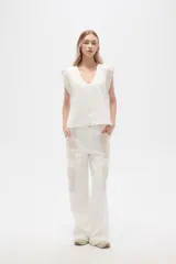 Blusa sin mangas de lino y viscosa, color blanco con laterales en beige, corte holgado y cuello en V.