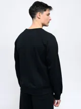 Buzo gris melange de felpa sin frisa, con cuello redondo y logo de Umbro bordado en azul marino en el pecho.