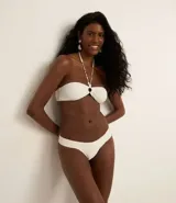 Bikini blanco de microfibra texturizada con hilo metalizado. La bombacha tiene laterales drapeados.