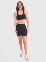 Calza corta deportiva negra de tiro alto, confeccionada en poliéster y spandex. Cuenta con banda de silicona para mayor sujeción, bolsillos laterales y certificación Bluesign.