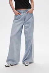 Pantalón de jean celeste de corte ancho con bolsillos y detalle de franja blanca en los laterales.