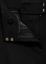 Pantalón de vestir negro acampanado, de tiro alto, con trabillas, bolsillos laterales y cierre oculto de botón, gancho y cremallera.