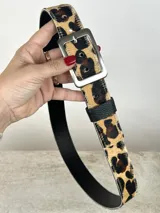 Cinturón de cuero con estampado animal print, hebilla cuadrada plateada y reverso negro.