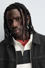 Sobrecamisa de denim de algodón negro con efecto lavado, corte relajado (relaxed fit). Presenta cuello solapa, cierre frontal con cremallera, manga larga con puño abotonado y bolsillo plastrón en el pecho.