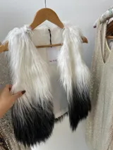 Chaleco de pelo largo blanco con degradé a negro, forrado en su interior.