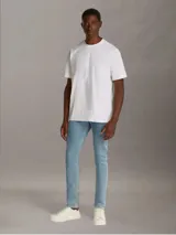 Remera blanca de algodón regenerado con cuello redondo, mangas cortas y corte regular. Estampado frontal con monograma de Calvin Klein en capas. Detalles distintivos de Calvin Klein Jeans.
