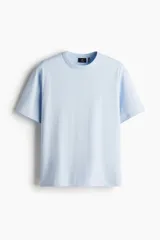 Remera celeste de corte holgado, cuello redondo ribeteado y mangas cortas. Confeccionada con tejido funcional COOLMAX®, una fibra de poliéster de secado rápido que elimina la humedad y regula la temperatura corporal.