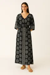 Vestido largo negro con estampado de mandalas grises, escote en V, mangas 3/4 y lazo ajustable en la cintura.