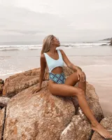 Traje de baño entero celeste con estampado geométrico en la parte inferior.