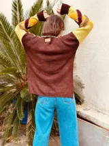 Sweater de punto color amarillo y marrón con diseño geométrico en el frente.