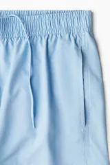 Short de baño celeste con elástico revestido y cordón para ajustar oculto en la cintura, bolsillos laterales y abertura corta en los lados. Suspensor interior de malla.