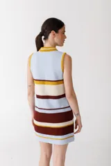 Vestido corto de punto con rayas horizontales en color rojo, marrón, beige y rosa. Tiene cuello alto con cierre de cremallera dorada y diseño sin mangas.