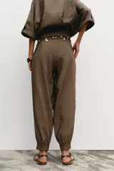 Pantalón de jogging color marrón, de tiro medio con cintura elástica ajustable con cordones, bolsillos delanteros y puños elásticos en los tobillos.
