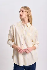 Camisa casual a rayas amarillas y blancas, de corte clásico y manga larga.