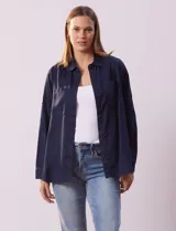 Camisa blanca de lyocell, marca Dash. Tiene cuello con solapa, abertura central con botones, mangas largas regulables con presilla y botón, y dos bolsillos delanteros aplicados.